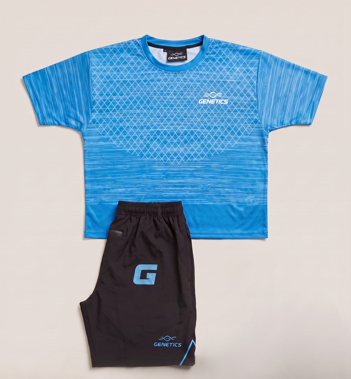 Genetics Training Kit in Blue: patterned tee and black shorts with a blue G lettermark, laid flat