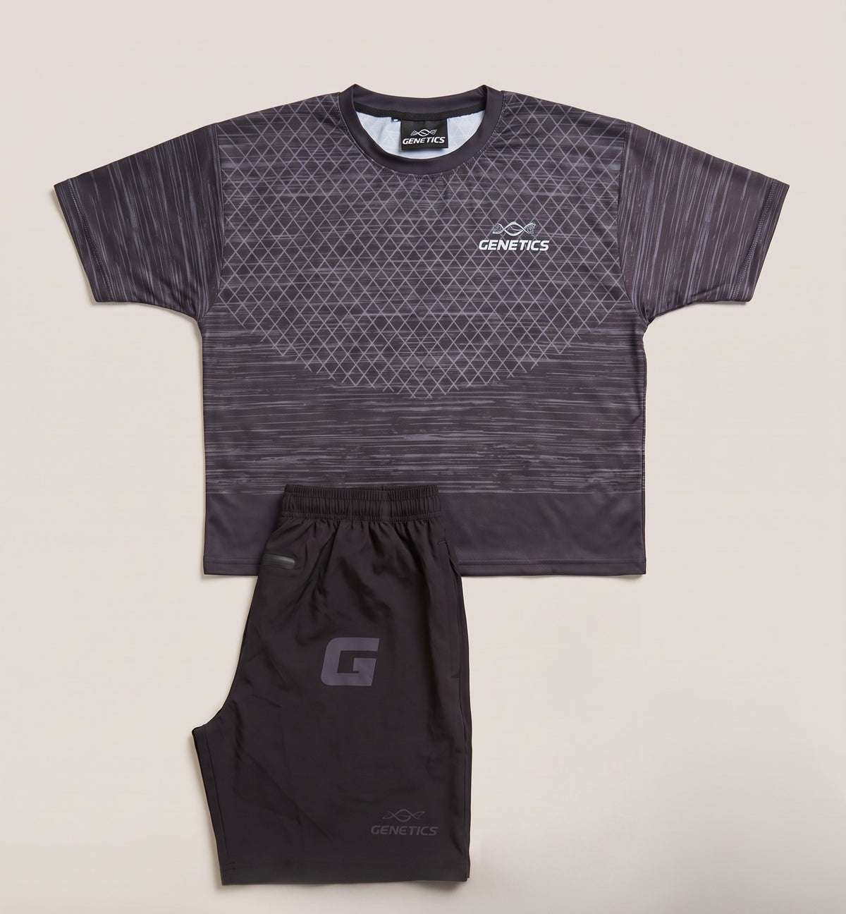Genetics Training Kit in Grey: patterned tee and black shorts with a grey G lettermark, laid flat